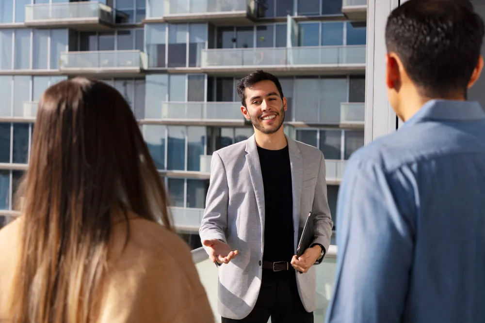 An RS Nadlan broker guides a couple on an apartment tour in Tzukei Aviv
