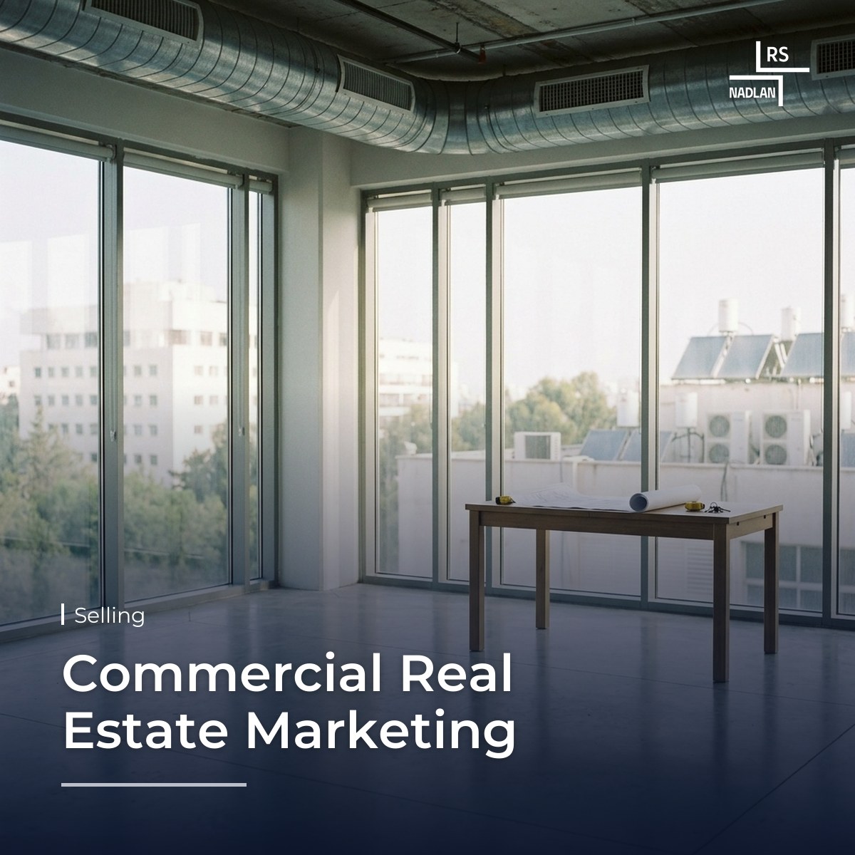 Bright, vacant office floor in an office building in north Tel Aviv with large windows and a floor plan on a table