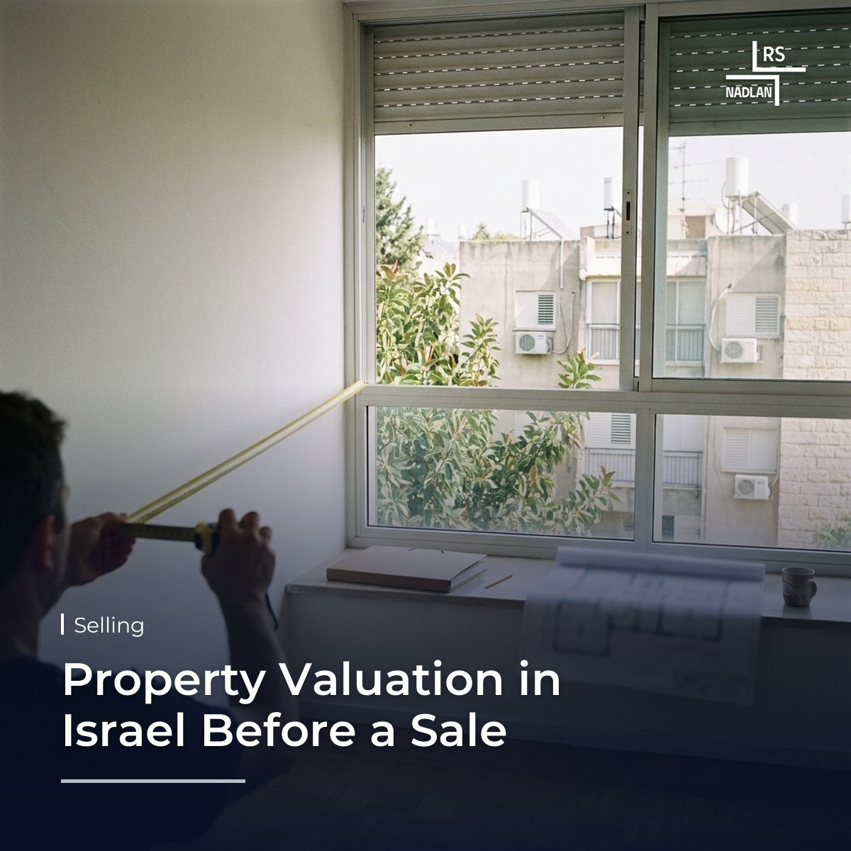 Seller measuring a room in a bright apartment in Ra'anana before a valuation, with a floor plan and a folder on the windowsill